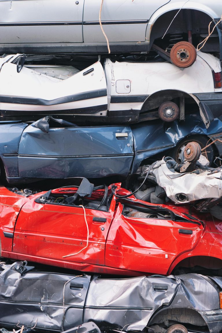 Crushed cars at a wrecking yard piled on top of one another