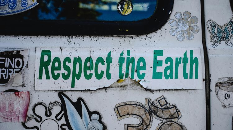 Aging, torn Respect the Earth sticker on the side of a van