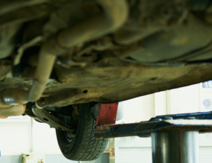 Looking up at underside of a car on a lift