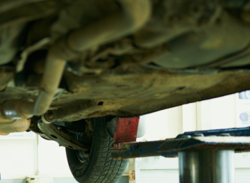 Looking up at underside of a car on a lift