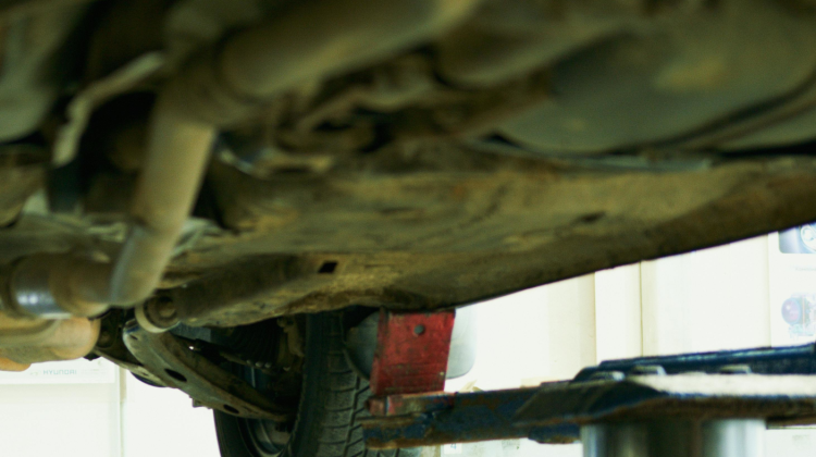 Looking up at underside of a car on a lift