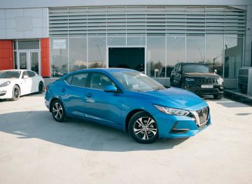 Blue car parked in front of a dealership