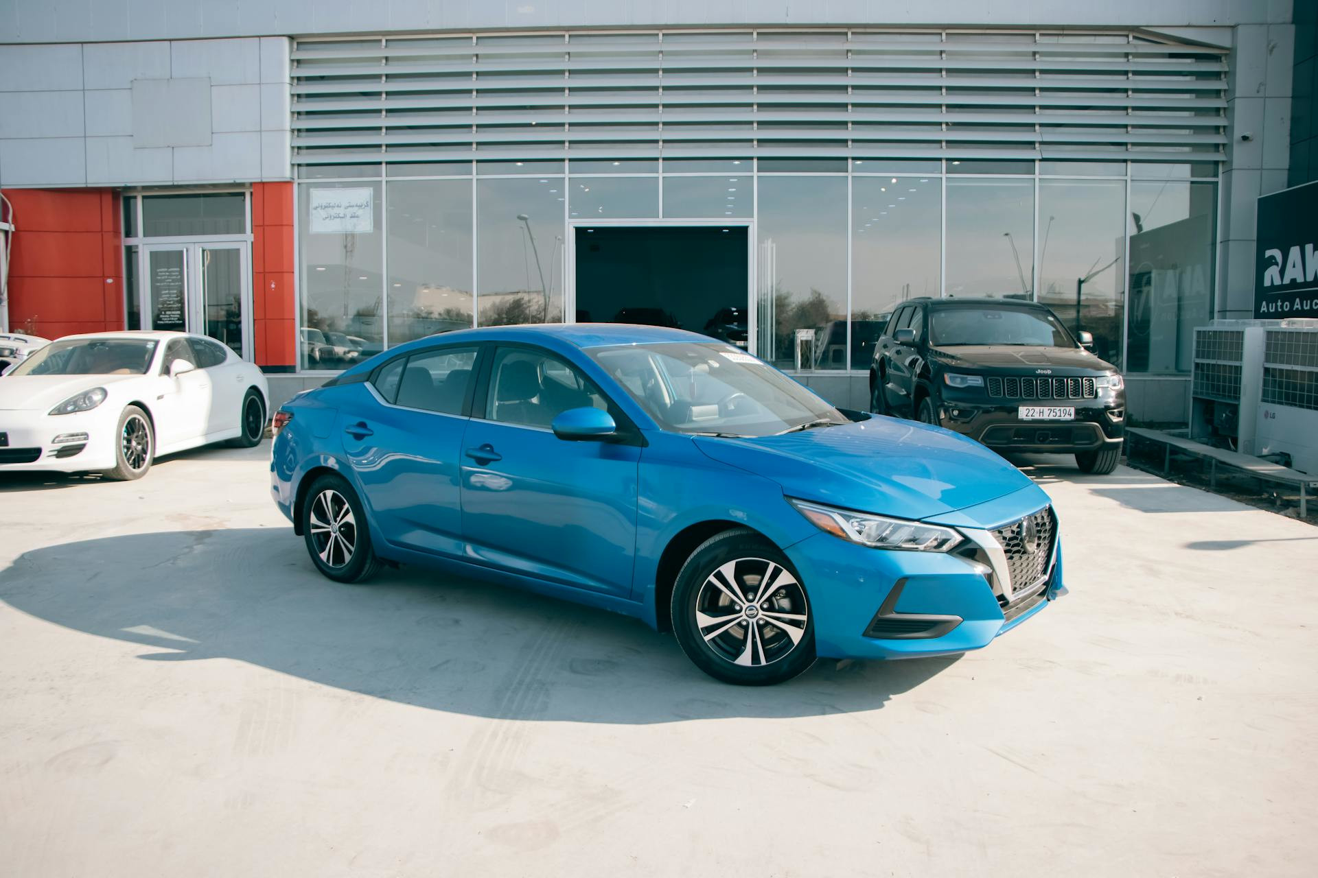 Blue car parked in front of a dealership